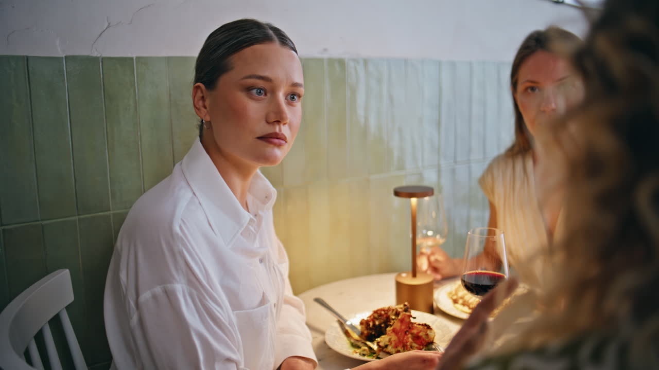 Three women sharing news dining at stylish restaurant closeup. Group friends