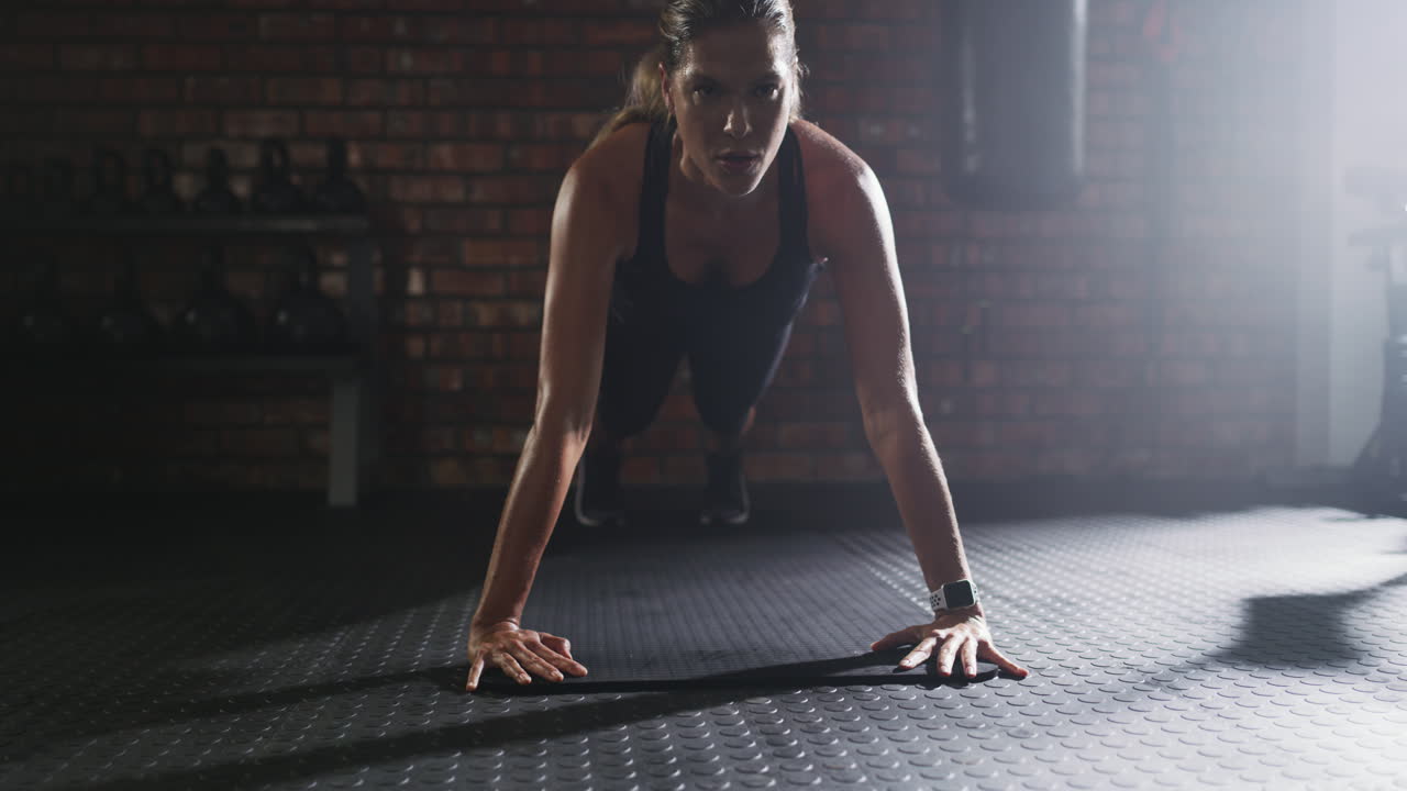 una giovane donna che fa push-up in palestra