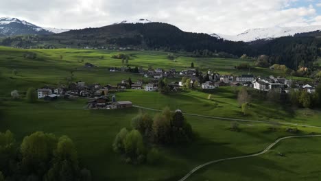 aerial view of a small residential settlement nestled in the lush natural greenery of obersaxen, graubünden, switzerland, showcasing serene alpine living