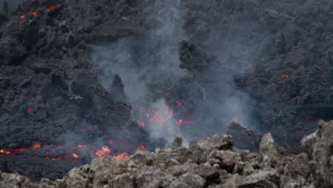 la lava derretida fluye lentamente desde el volcán grindavik en el cráter sundhnúkur, islandia, con humo que se eleva