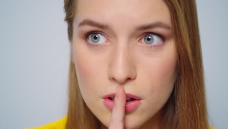 Closeup-young-attractive-woman-showing-silence-sign-on-grey-background.