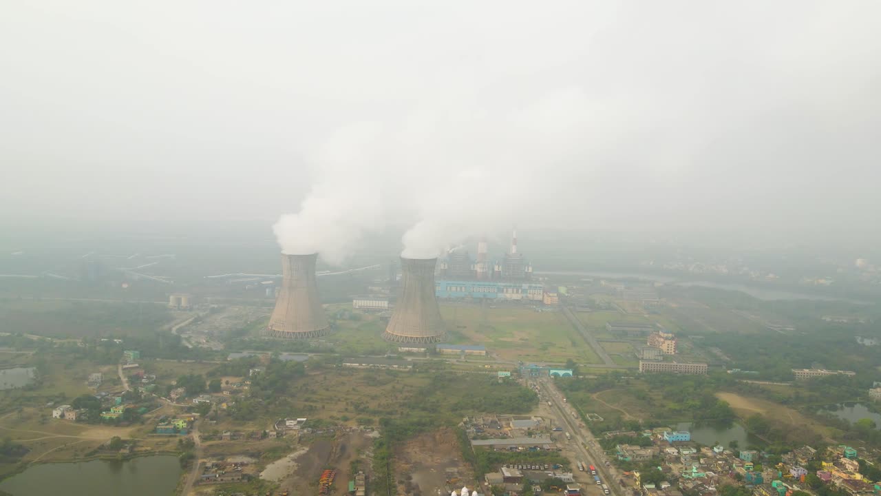 인도의 산업 구역의 드론 촬영, 굴에서 아오르는 연기가 스카이라인을 지배하고 있습니다.
