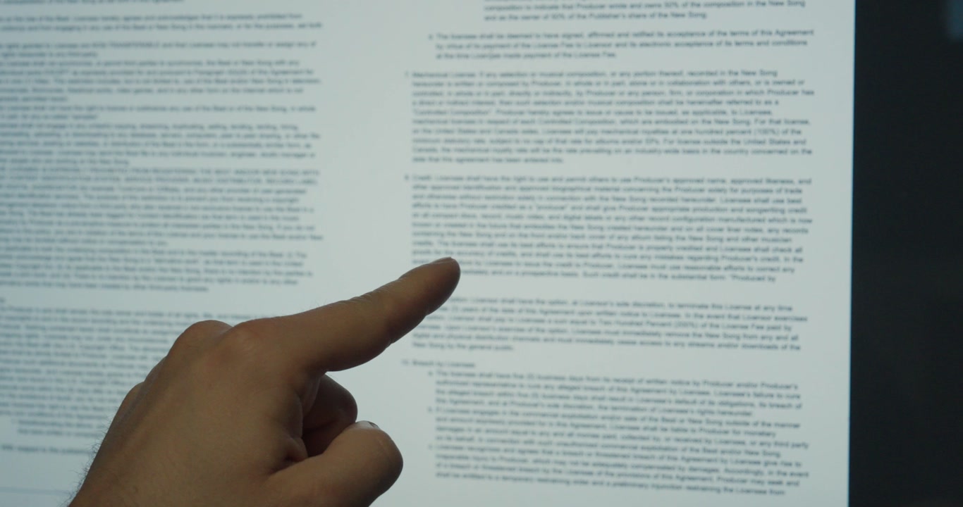 Close-up of a finger pointing at contract terms on a screen. Concept of legal review, agreement and business analysis.