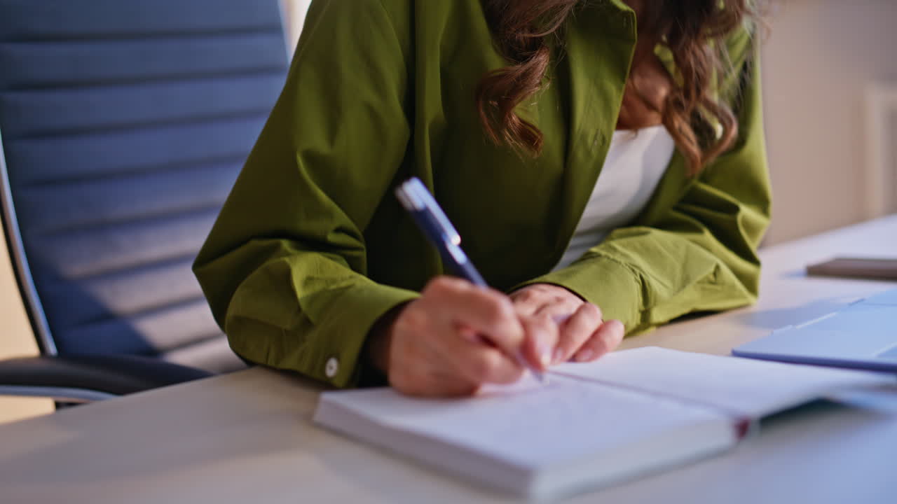 Woman writing in a notebook at her desk