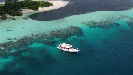 boat over tropical crystal clear water aerial 4k