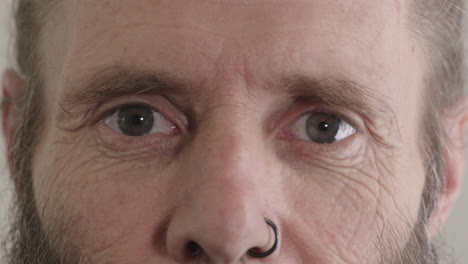 hombre de mediana edad ojos mirando a la cámara hombre maduro con anillo en la nariz macro de cerca