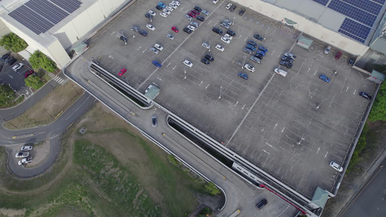 volando sobre el estacionamiento del centro de la ciudad de robina con paneles solares en la azotea en la ciudad de robina, costa dorada, queensland