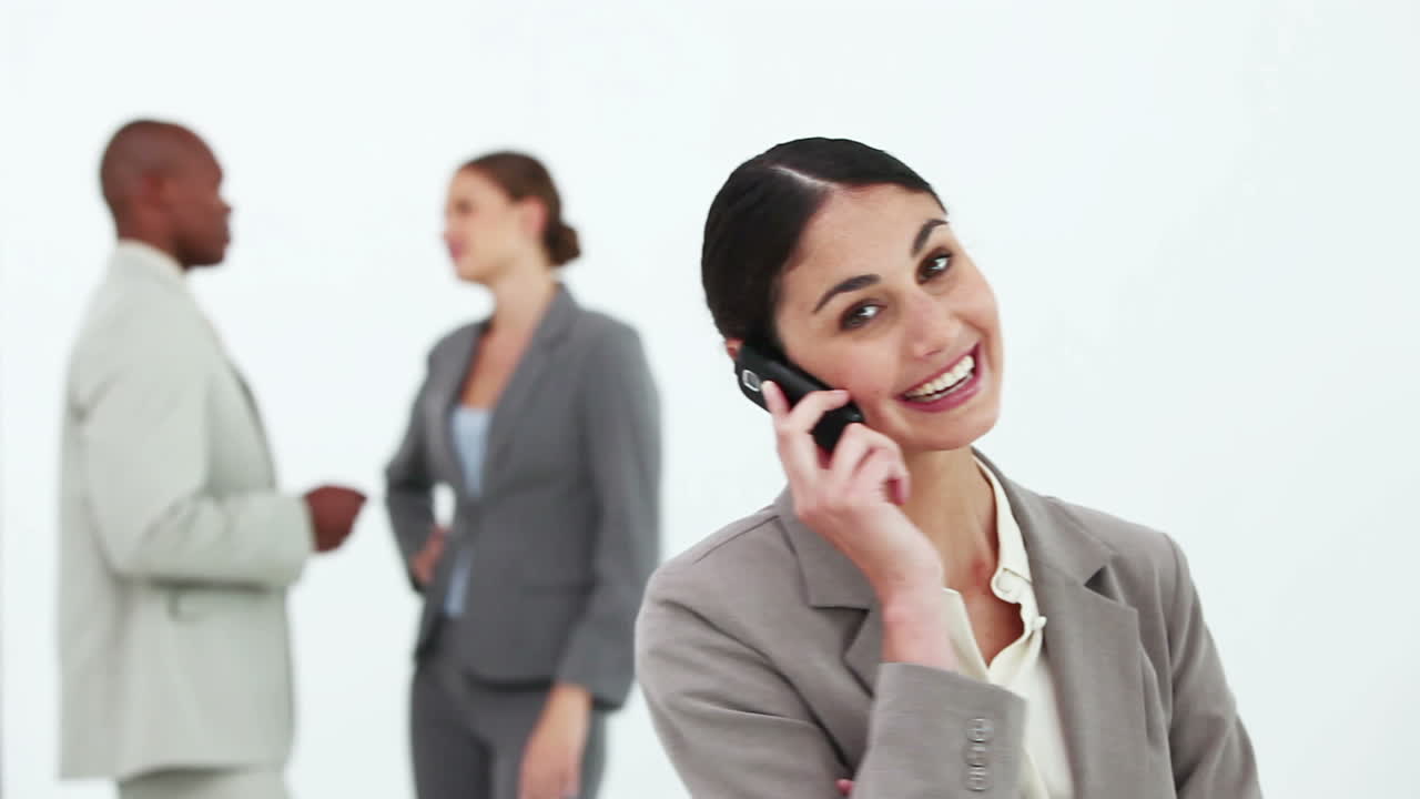una mujer de negocios de cabello negro al teléfono.