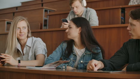 el grupo de estudiantes alegres y felices sentados en una sala de conferencias antes de la lección.