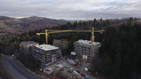 toma aérea de un sitio de construcción en una montaña cubierta de bosque