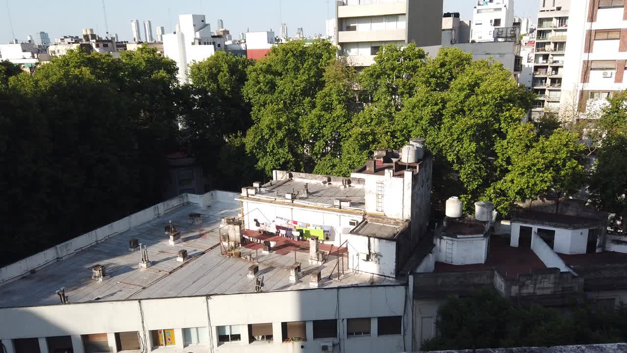 Aerial top view of urban terrace with clothes drying among trees in a south american town