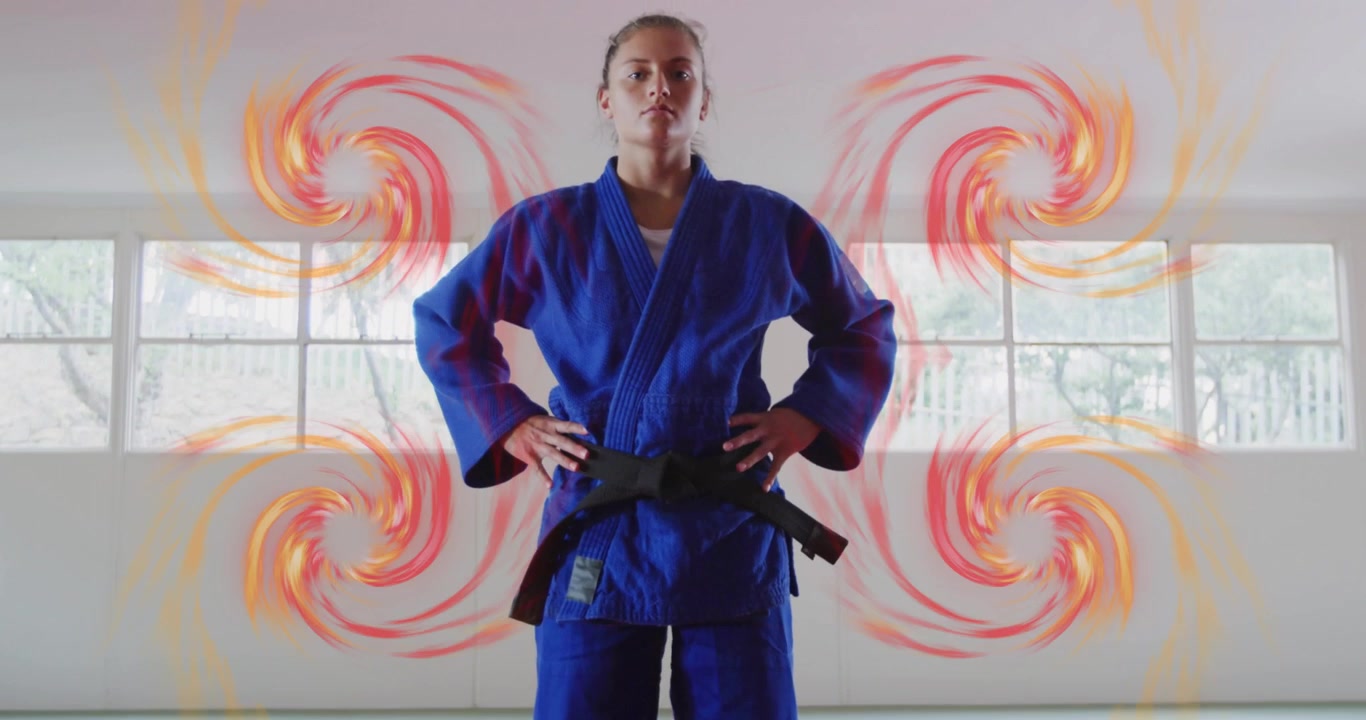 Confident Young Woman in Judo Uniform with Black Belt Standing in Dojo