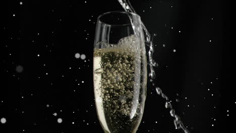 animation of white specks floating over glass of champagne on black background