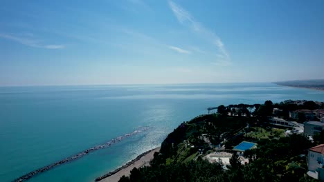 Waves-of-Adriatic-Sea-breaking-in-Spiaggia-del-Frate,-in-Numana-village,-Italy-drone-aerial-footage