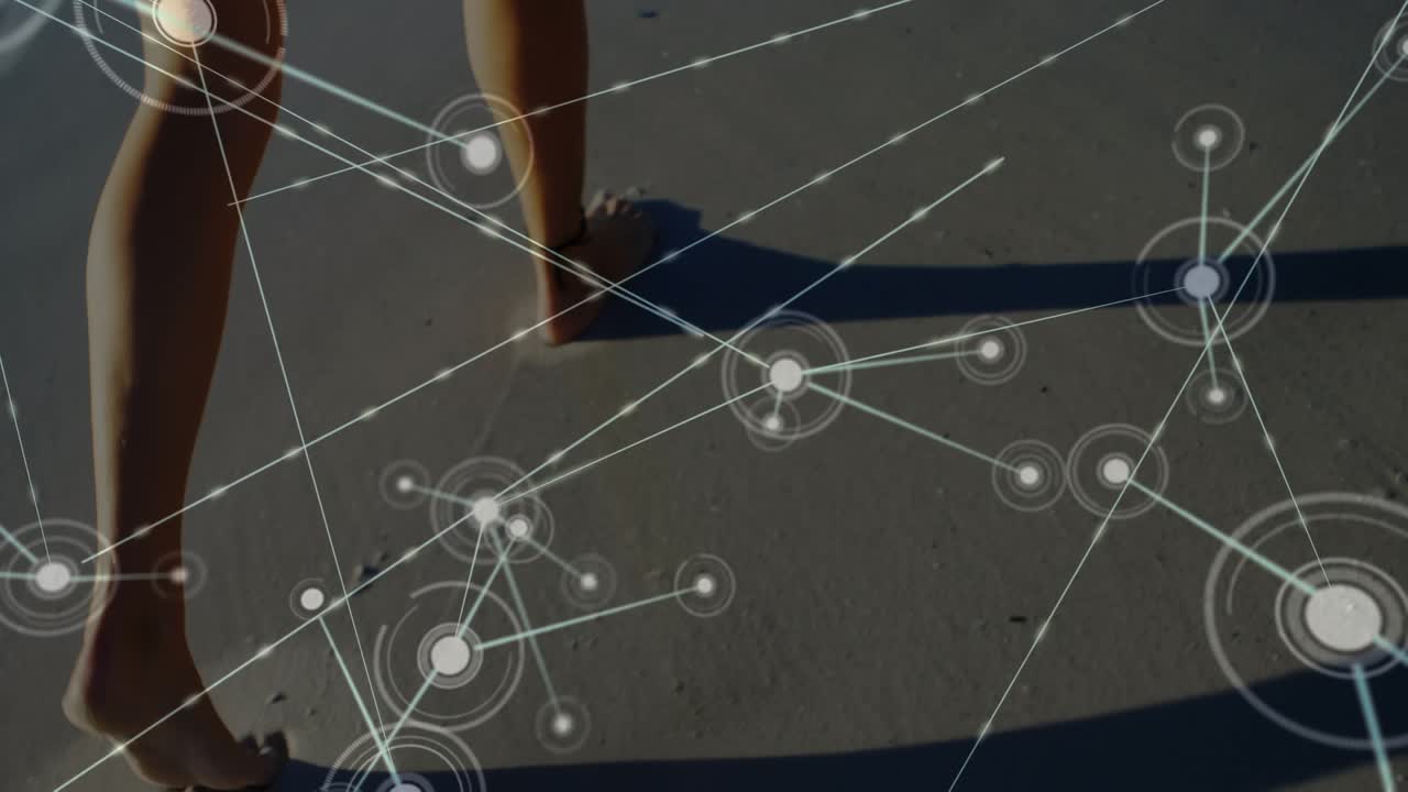 Animation of connections over legs of caucasian woman walking on beach at sunset