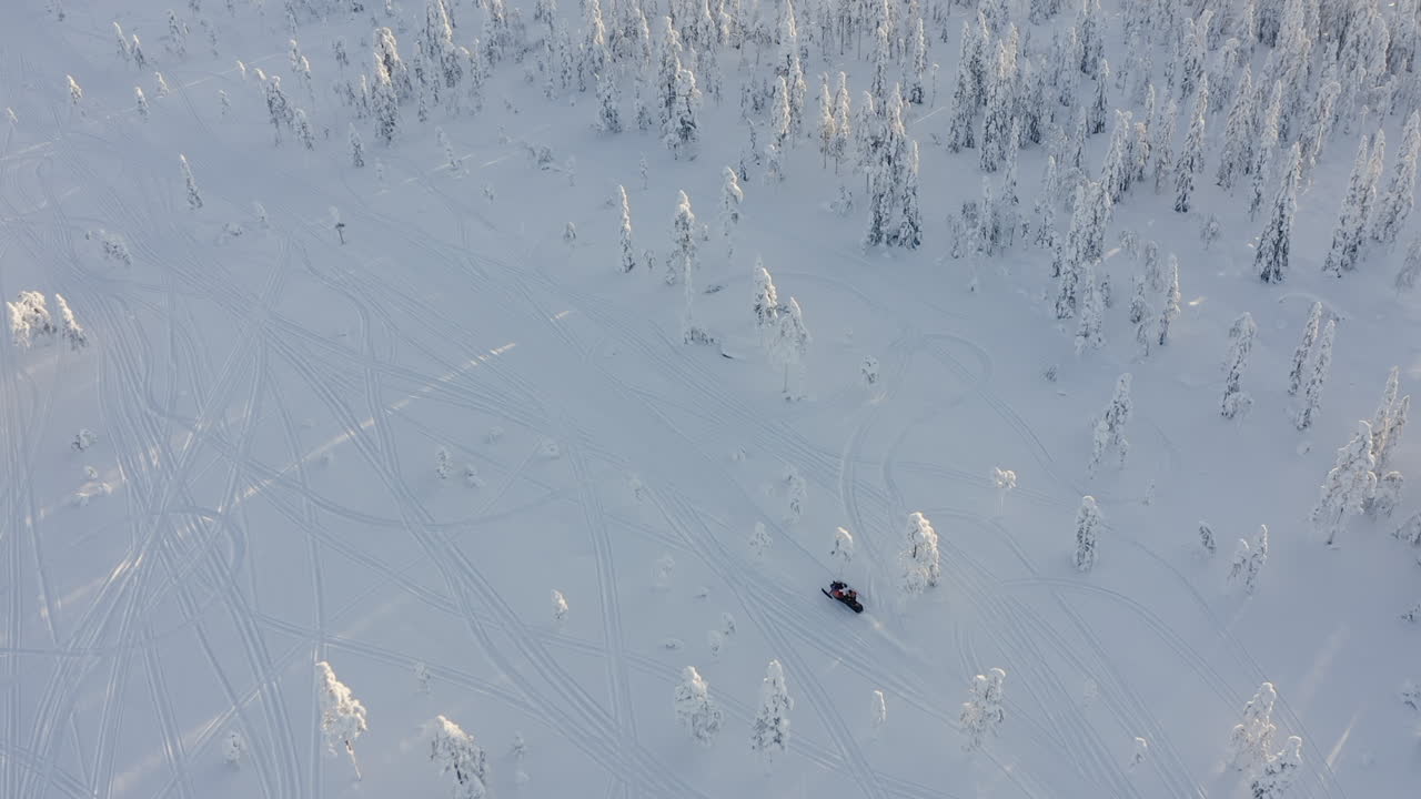 toma de un dron de una moto de nieve cerca de un denso bosque nevado en branäs, suecia
