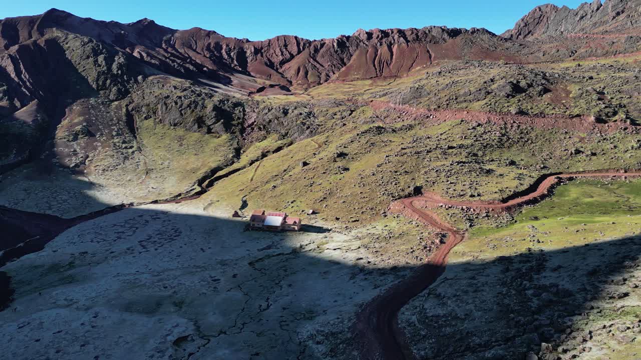 Drone video of a remote lodge from Andean loges, near vinicunca perus rainbow mountain. The logde is located between mountains surrounding with frost in the morning sun