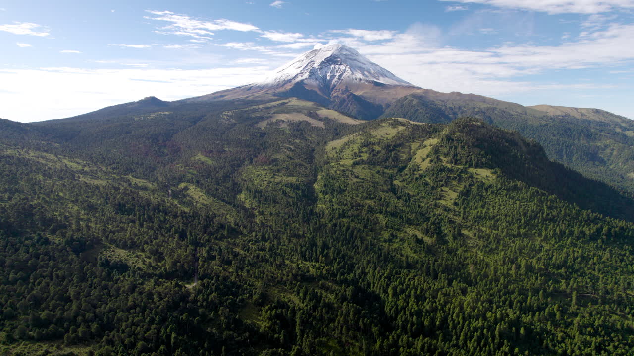 drone hacia atrás en descenso corto que muestra la cima nevada del volcán popocatepetl en la ciudad de méxico