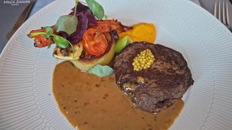 gourmet steak dinner with whole grain mustard, vegetables, and sauce