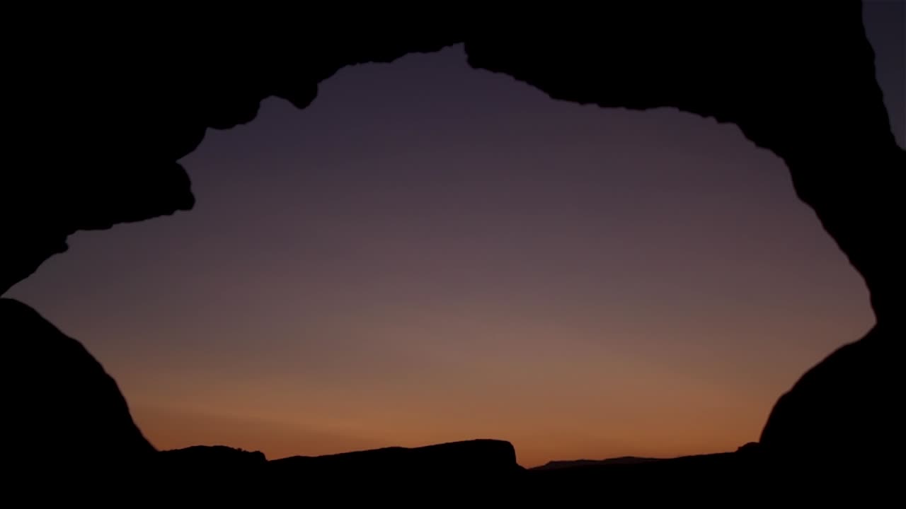 puesta de sol a través de un arco de roca