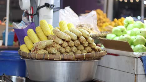 steaming corn cobs atop a pile of potatoes.