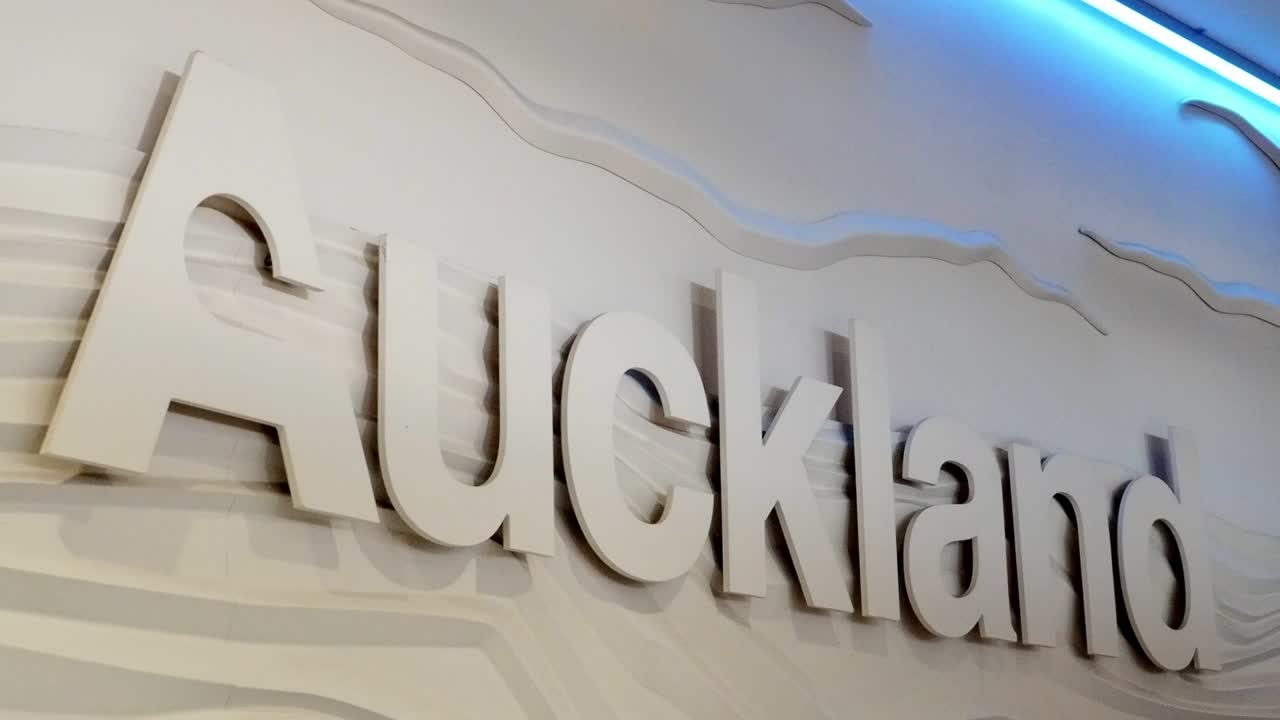 signo en la pared de la sala de llegadas del aeropuerto de auckland