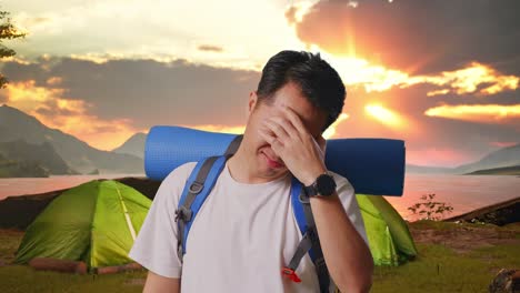man with headache while camping