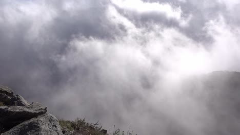 low flying clouds floating up a rocky surface