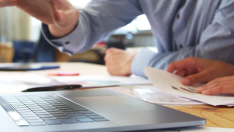 two colleagues using laptop, close up of hands and keyboard