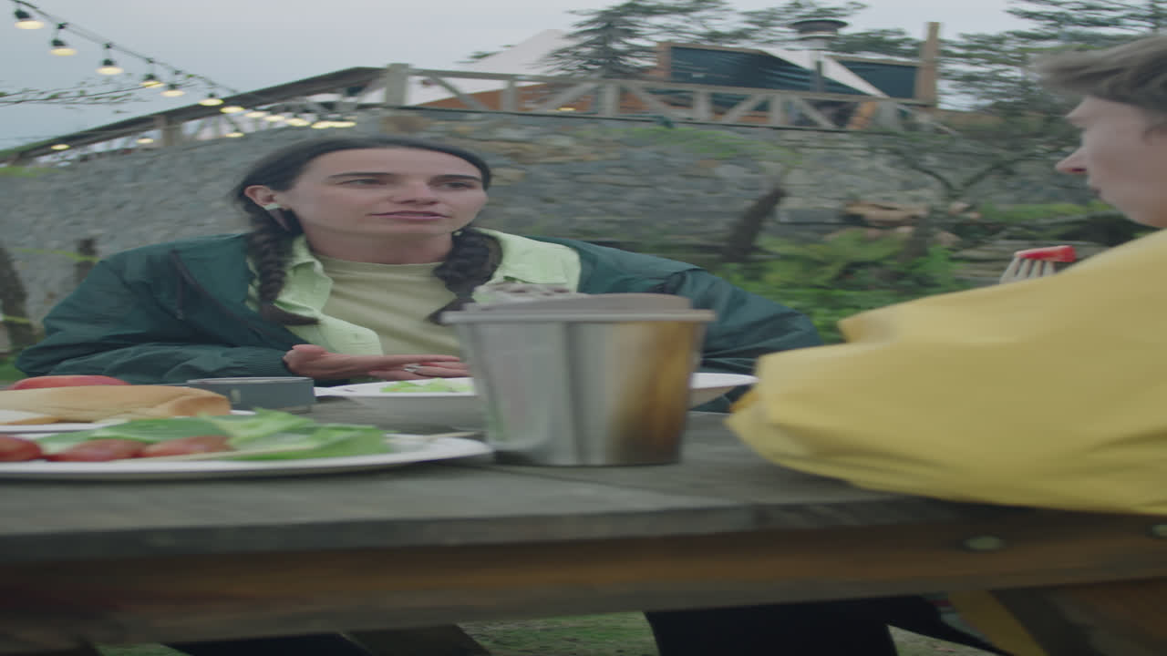 Female Tourist Having Dinner with Friends at Glamp