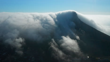 drone shot of lion's head with lots of clouds over cape town city in south africa