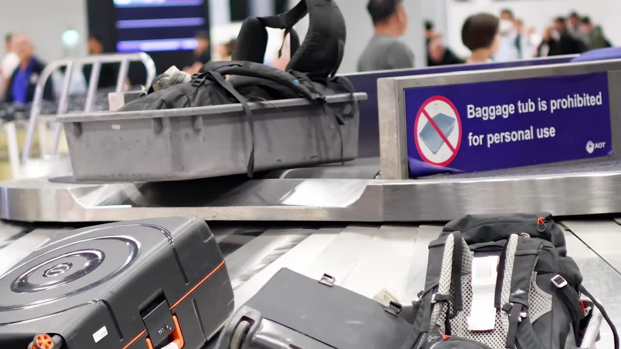 Passengers retrieving bags from conveyor belt