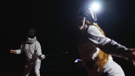 two women in fencing gear competing in a match