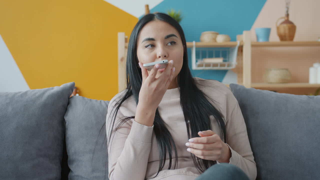 Woman talking on her smartphone at home