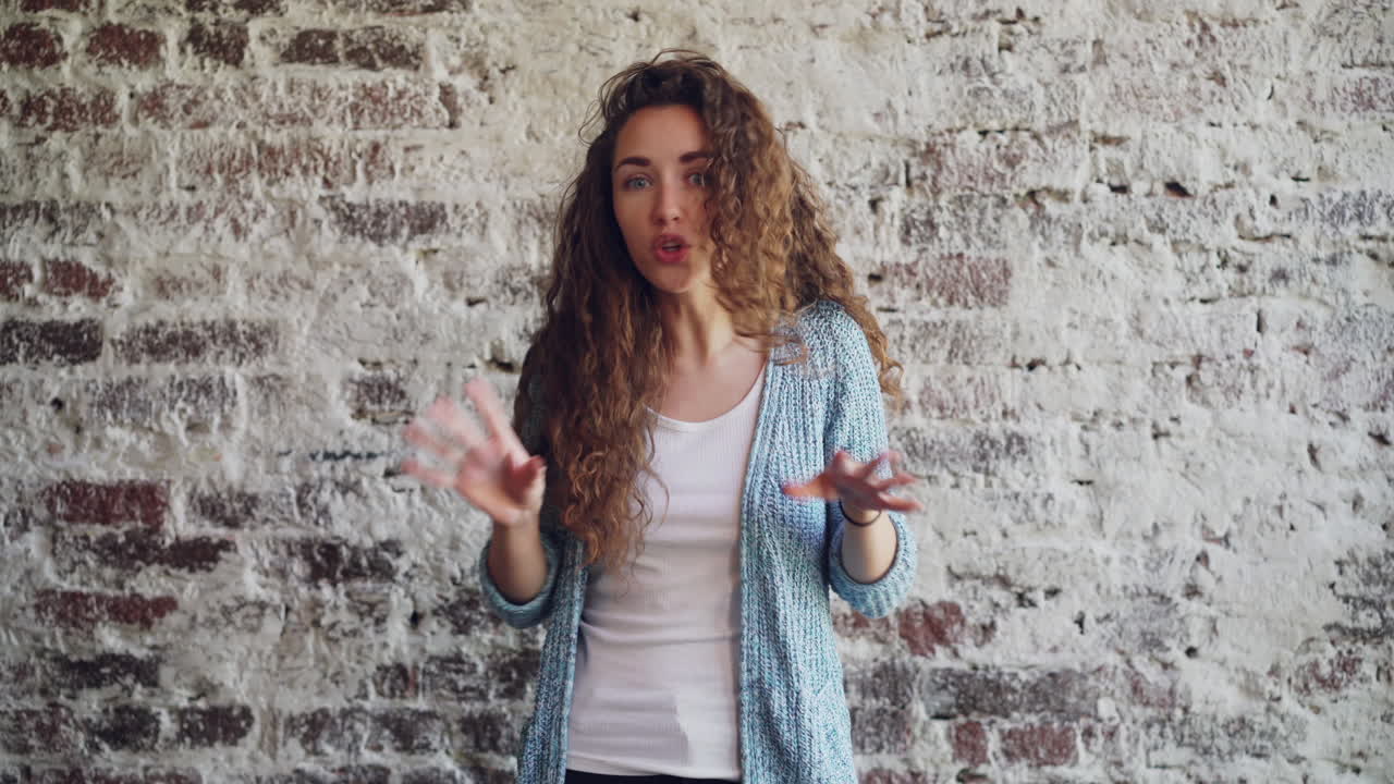 Woman Talking in Front of a Brick Wall