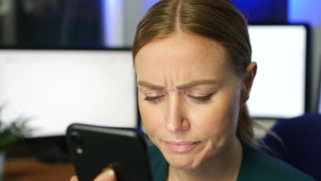 Stressed-and-frustrated-girl-using-a-phone-in-an-office