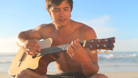 handsome man singing and playing guitar