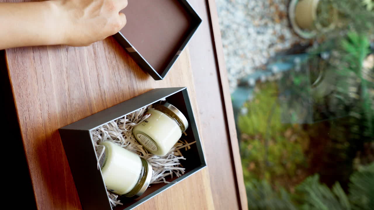 선물 상자 에 불 용기 를 포장 하는 손