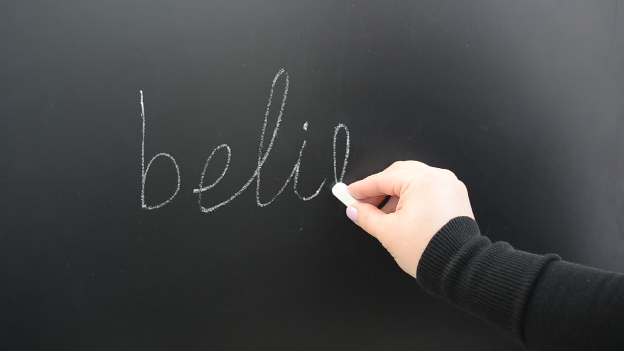 We write the word believe on a board. Inscription chalk on a board