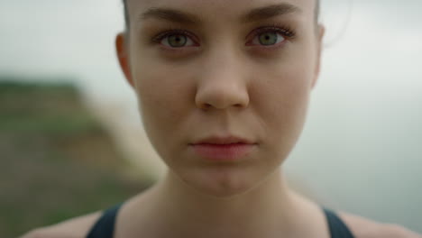 closeup woman opening eyes standing on coast hill. girl doing breathing exercise