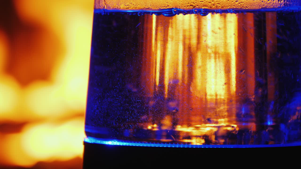 역광 전기 주전자에 물이 끓는다 배경에 있는 불이 배경에서 타오른다