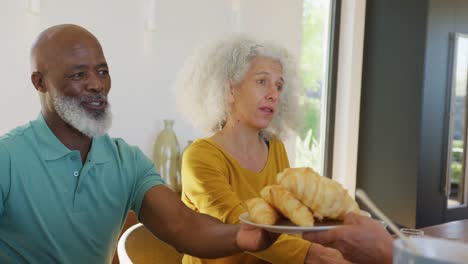 happy senior diverse people having breakfast at retirement home