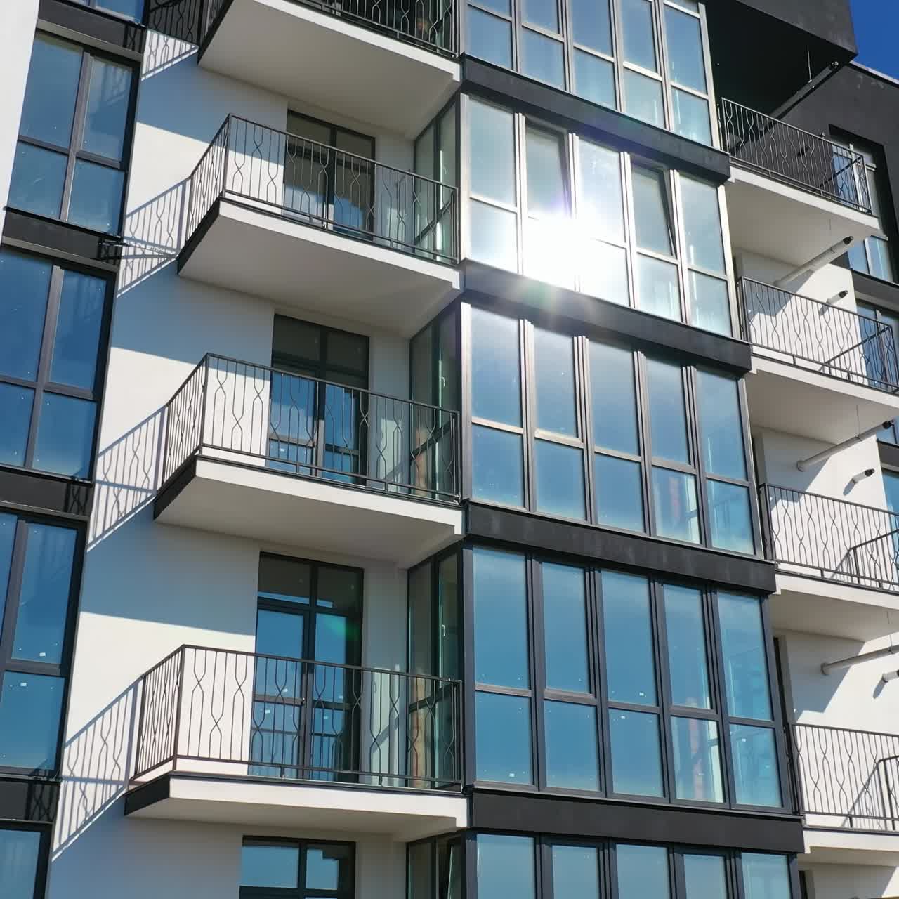 Beautiful design of multistorey building. New apartment with balconies against blue sky. Exterior of residential building