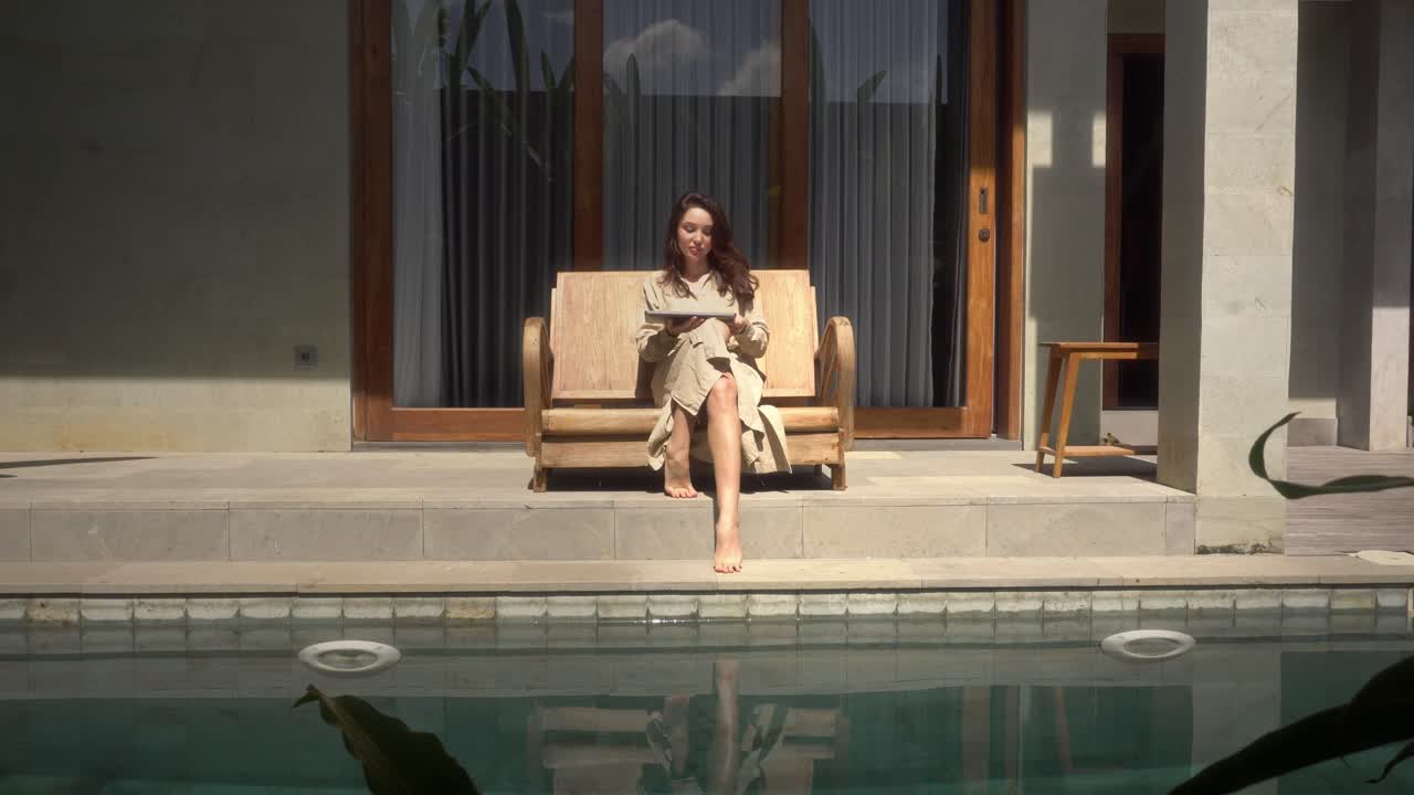 mujer de negocios trabajando en línea en su casa de lujo con piscina y usando computadora portátil para trabajar desde casa temprano en la mañana, mujer usuario profesional usando tecnología haciendo trabajo remoto en línea