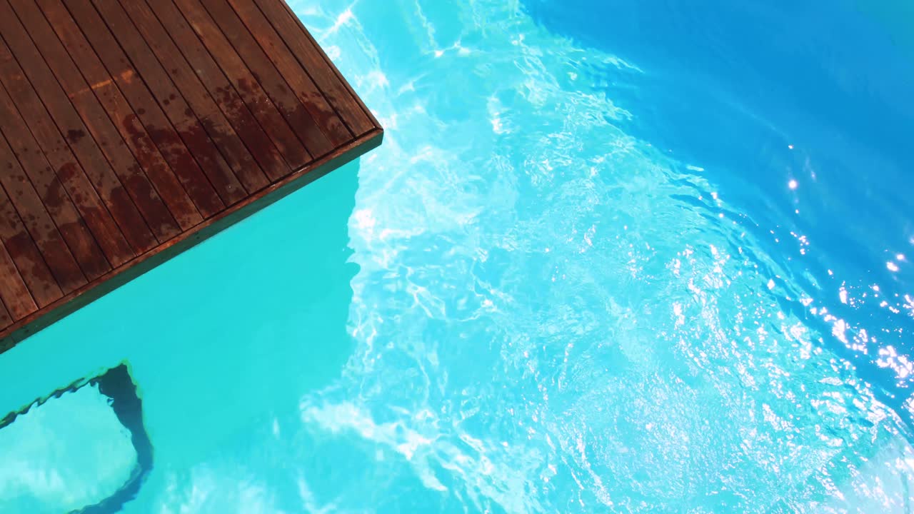 Brünette taucht in klaren blauen Pool