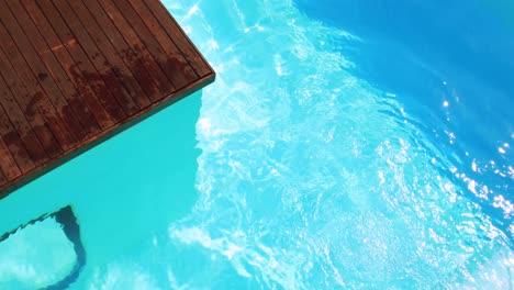 brunette diving into clear blue pool