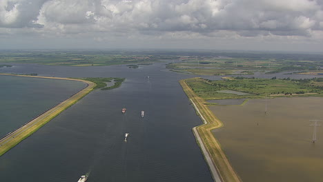 Vuelo-Suave-De-Verano-Sobre-Las-Tierras-Holandesas-Siguiendo-El-Canal-En-Zelanda-Con-Bonitas-Nubes