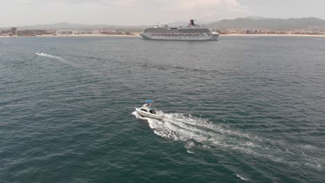 Aerial-View-of-Boats-and-Cruise-Ship-Driving-In-Ocean-Along-Mountain-Coastal-Town