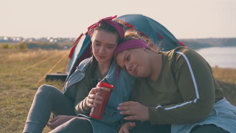 girl hikers have romantic date in calm camp at sunset