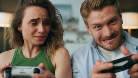 pareja competitiva sosteniendo gamepads retrato en casa. mujer nerviosa perdiendo video pov